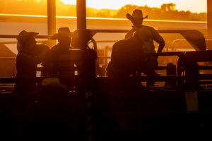 The sun sets behind a group of cowboys on the chutes at the rodeo in Dripping Springs, Texas, July 26th, 2019.